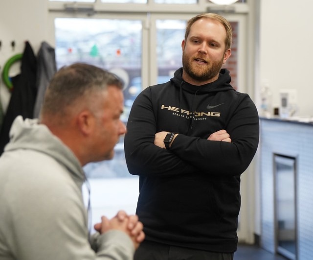 Physical therapist Shawn Herlong smiles while working with a patient at Herlong Sports Physical Therapy